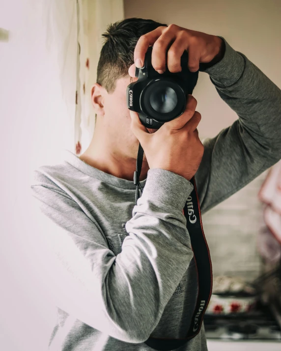 a man taking a picture of himself with a camera, by Robbie Trevino, unsplash contest winner, wearing a grey robe, portrait of tom holland, lgbtq, wearing casual clothing