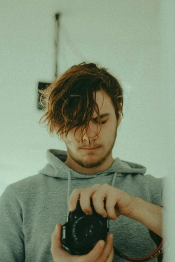 a man taking a picture of himself in a mirror, unsplash, brown messy hair, pewdiepie, soft light from the side, chillhop