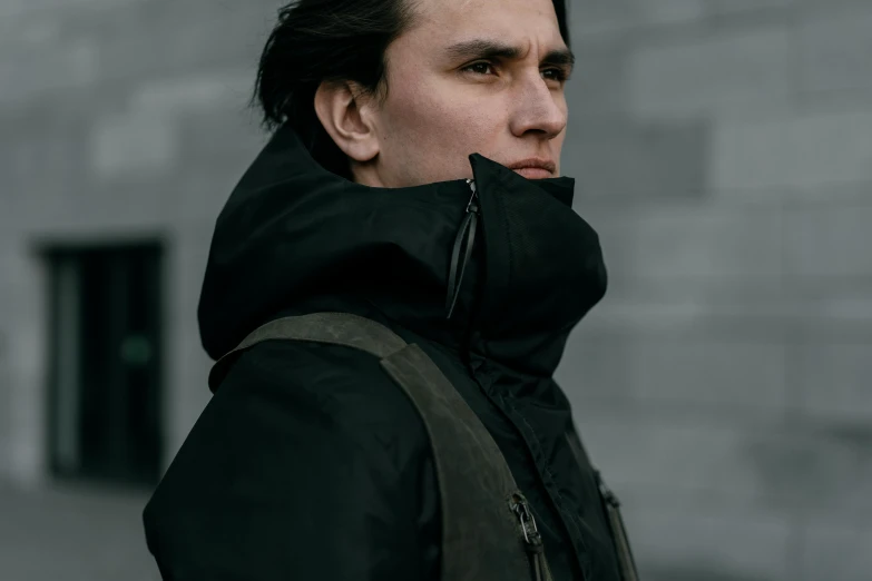 a man standing in front of a brick building, a character portrait, unsplash, model wears a puffer jacket, tactical, profile pic, technical vest