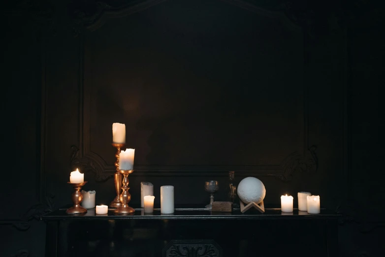 a bunch of candles sitting on top of a table, inspired by Elsa Bleda, trending on pexels, baroque, dark show room, displayed on an altar, set photo, halloween