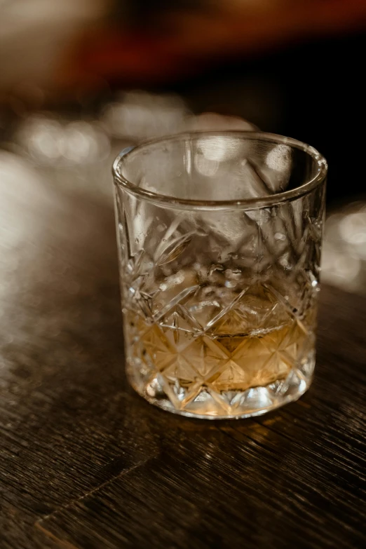 a glass of whiskey sitting on top of a wooden table, by Jessie Algie, renaissance, slide show, vanilla, battered, uncropped