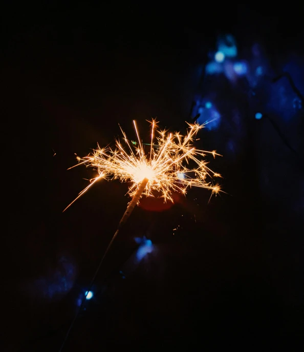 a close up of a sparkler in the dark, pexels, light and space, starry sky 8 k, in black blue gold and red, new years eve, instagram post