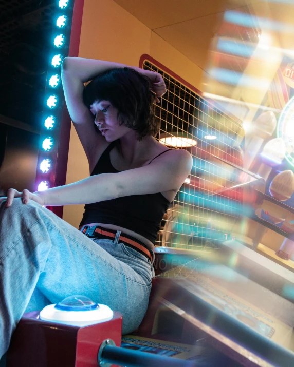 a woman sitting on the ground in front of a carnival ride, inspired by Elsa Bleda, trending on pexels, gaming room in 2 0 4 0, portrait of max caulfield, tactile buttons and lights, non binary model