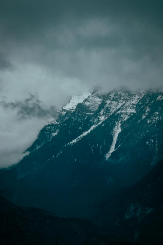 a mountain covered in snow under a cloudy sky, inspired by Elsa Bleda, trending on unsplash, baroque, dark emerald mist colors, looking left, himalayas, multiple stories