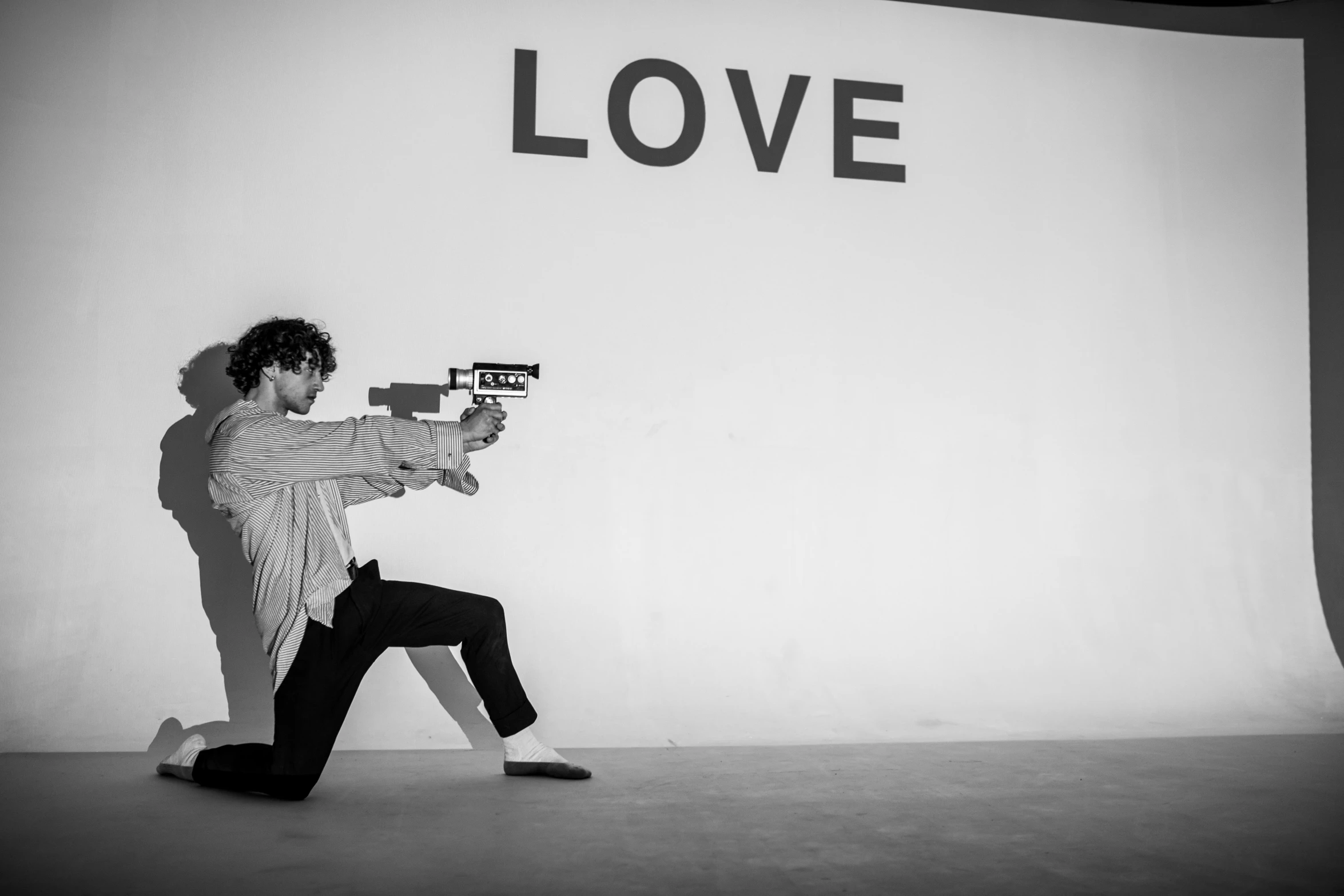 a black and white photo of a man holding a gun, an album cover, inspired by Carl Gustaf Pilo, unsplash, graffiti, alec soth : : love, live performance, frank dillane, shooting laser