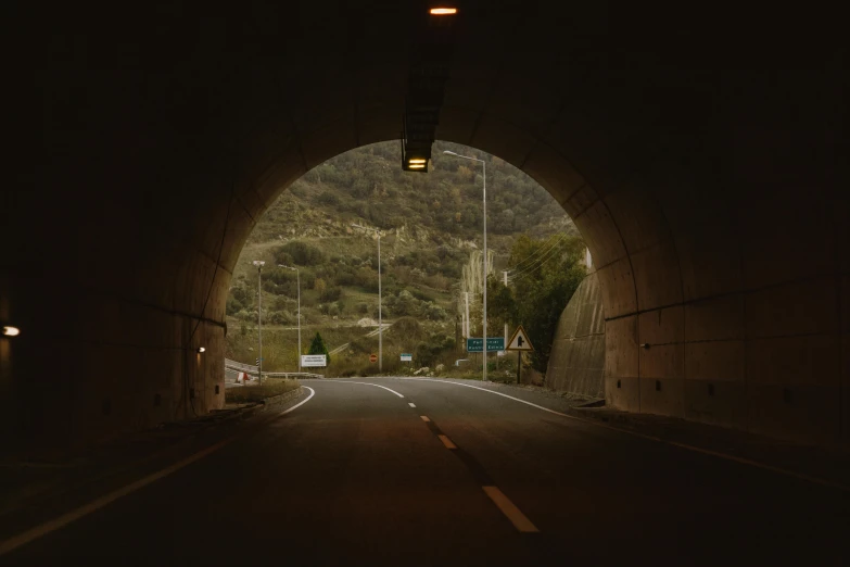 a dark tunnel with a light at the end, by Elsa Bleda, hyperrealism, road between hills, 8k 28mm cinematic photo, real engine 5 cinematic, **cinematic