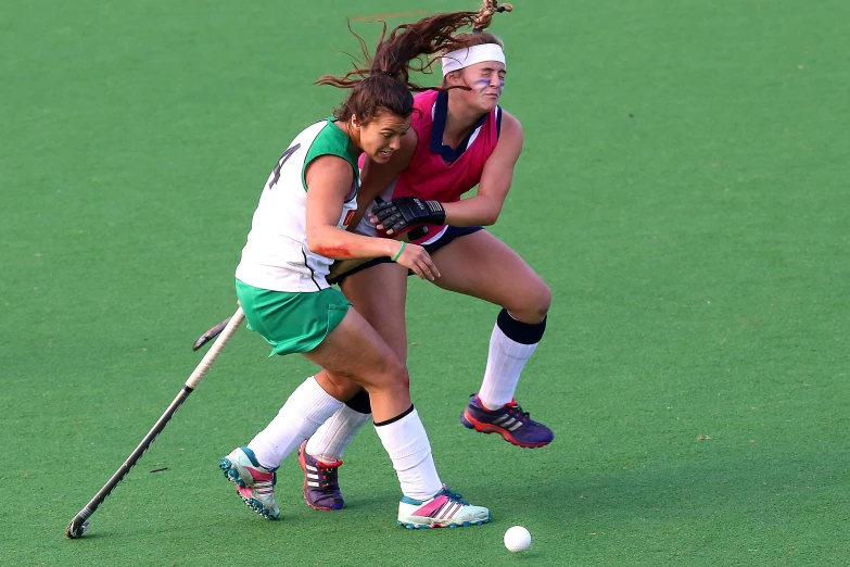 a couple of women playing a game of field hockey, green and pink, lynn skordal, holding close, more intense