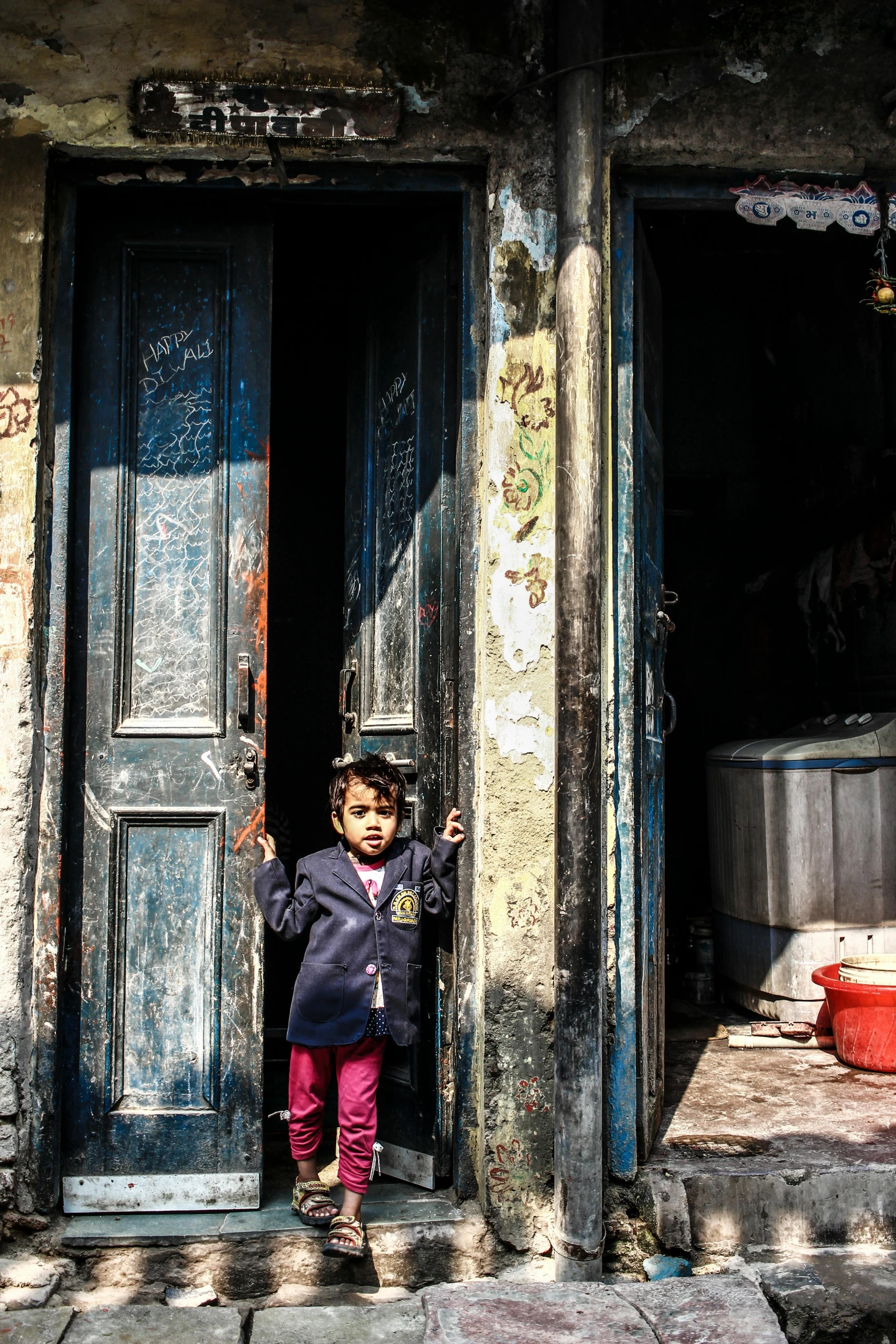 a little girl standing in the doorway of a building, by Youssef Howayek, standing in the streets, mohamed chahin, high resolution photo, multiple stories