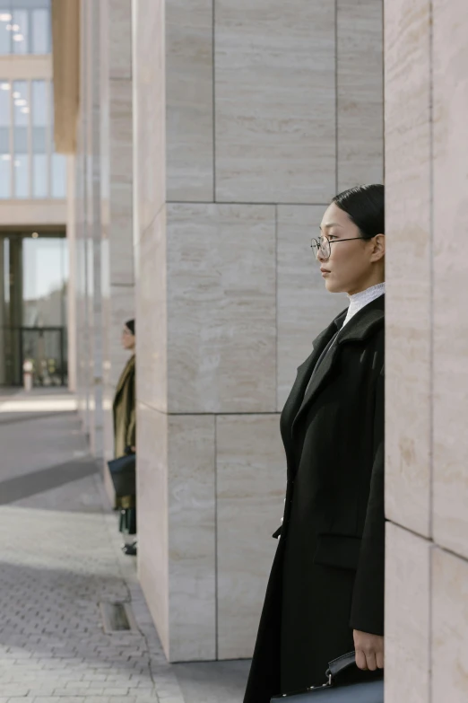 a woman standing in front of a building with a suitcase, inspired by Fei Danxu, visual art, lawyer suit, still from film, waiting behind a wall, two people