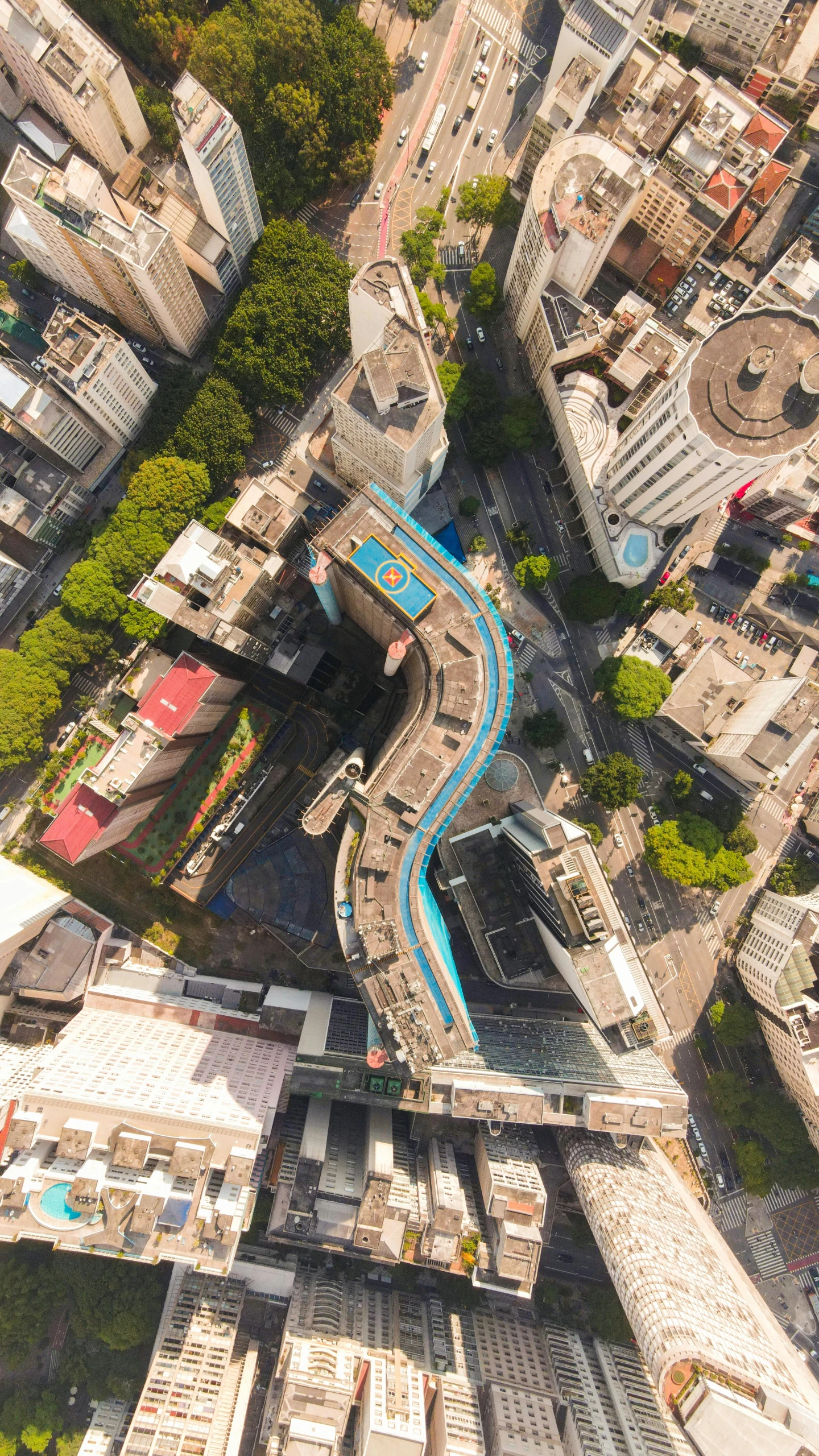 a view of a city from the top of a building, by Felipe Seade, infinity concentric pool, monorail, aerial, cyan