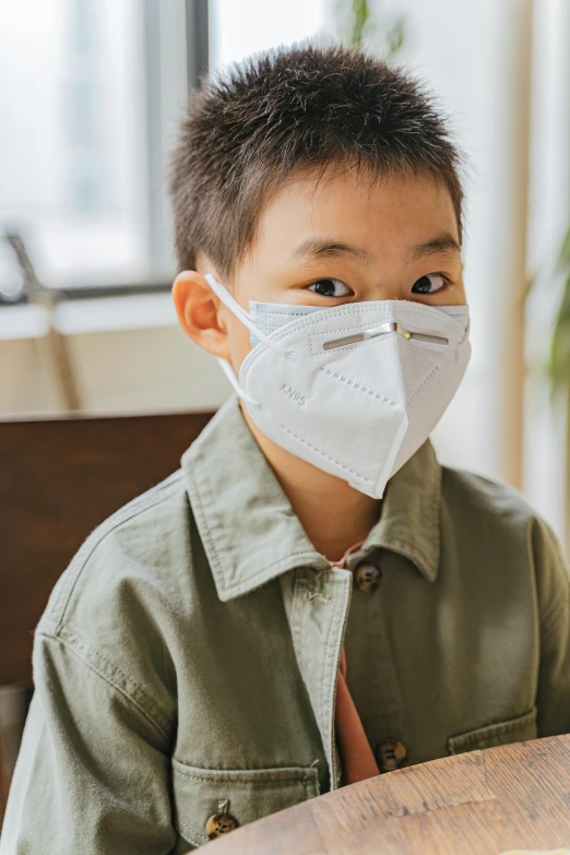 a young boy sitting at a table wearing a face mask, jen yoon, closeup on face, thumbnail, asian