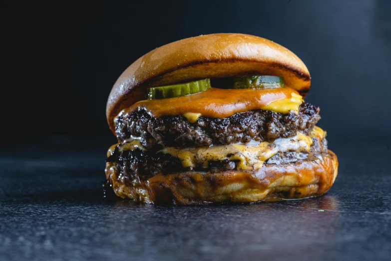 a cheeseburger sitting on top of a table, a portrait, unsplash, gooey skin, inside a cavernous stomach, very crispy, charred