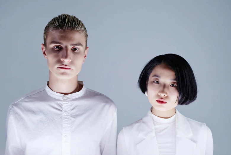 a couple of people standing next to each other, an album cover, inspired by Wang Duo, unsplash, antipodeans, white hime cut hairstyle, serious faces, healthcare, teamlab