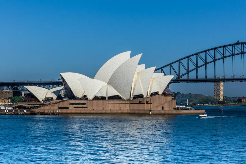 the sydney opera house with the sydney harbour bridge in the background, pexels contest winner, clear blue skies, brown, khedival opera house, slide show