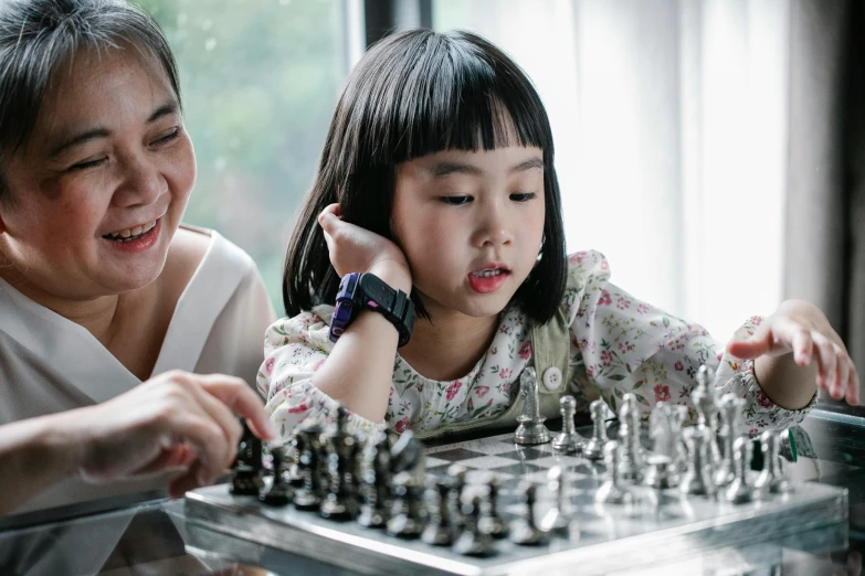 a woman and a child playing a game of chess, pexels contest winner, young asian girl, thumbnail, high quality image, profile picture 1024px