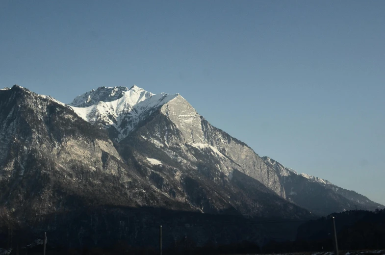 the mountains are covered in snow on a clear day, a picture, by Andries Stock, unsplash, visual art, no cropping, taken on iphone 1 3 pro, giant imposing mountain, multiple stories