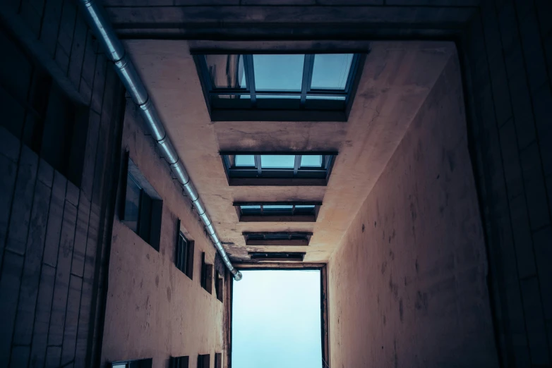 a long hallway with a skylight above it, inspired by Elsa Bleda, unsplash, brutalism, low angle facing sky, industrial colours, instagram picture, space seen outside from a window