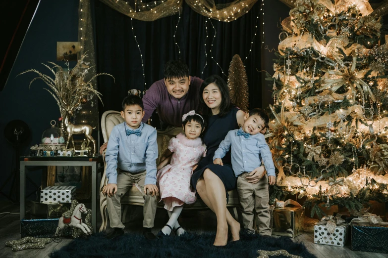 a family posing for a picture in front of a christmas tree, a portrait, pexels contest winner, hurufiyya, asian male, avatar image, full shot photo, maintenance photo