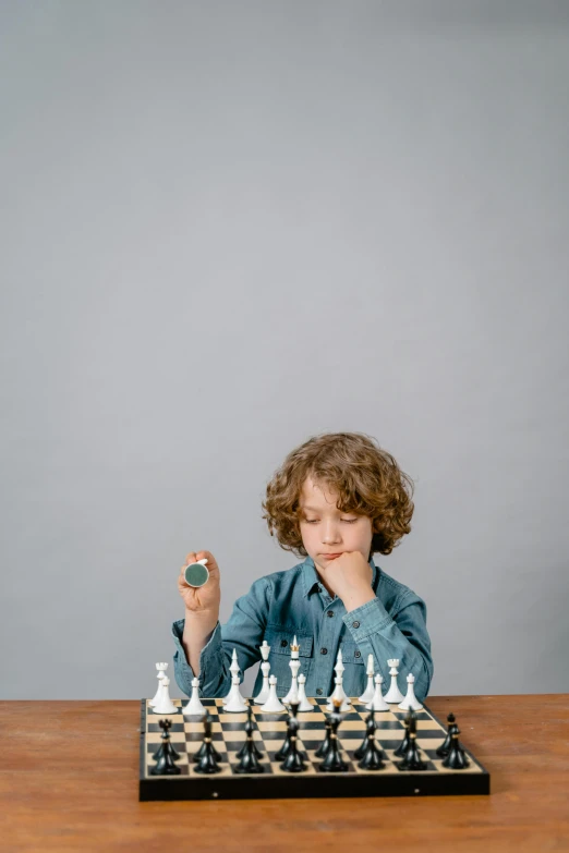 a young boy playing a game of chess, an album cover, unsplash, studio portrait photo, 15081959 21121991 01012000 4k, ignant, holding trident
