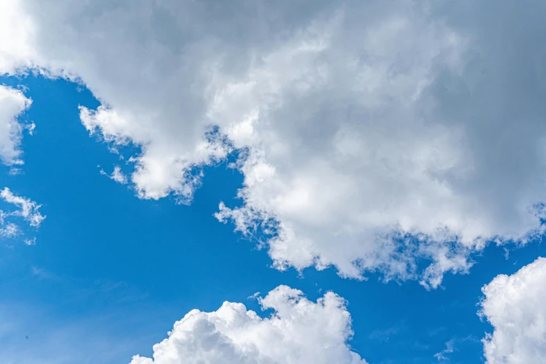 a man flying a kite on top of a lush green field, unsplash, minimalism, giant cumulonimbus cloud, low angle 8k hd nature photo, hd footage, bright blue sky