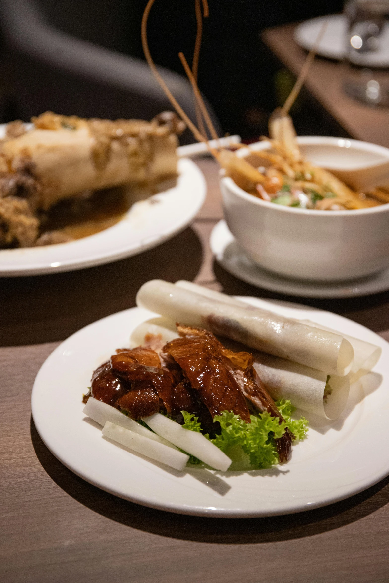 a wooden table topped with plates of food, inspired by Tan Ting-pho, medium shot angle, white, chicken, thumbnail