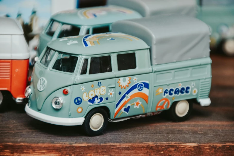 a couple of toy cars sitting on top of a wooden table, a cartoon, unsplash, graffiti, kombi, detailed model, peace sign, close up shot from the side