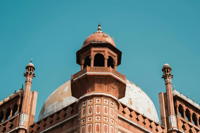 the top of a building with a clock on it, pexels contest winner, hurufiyya, with great domes and arches, mogul khan, thumbnail, brown and cyan color scheme