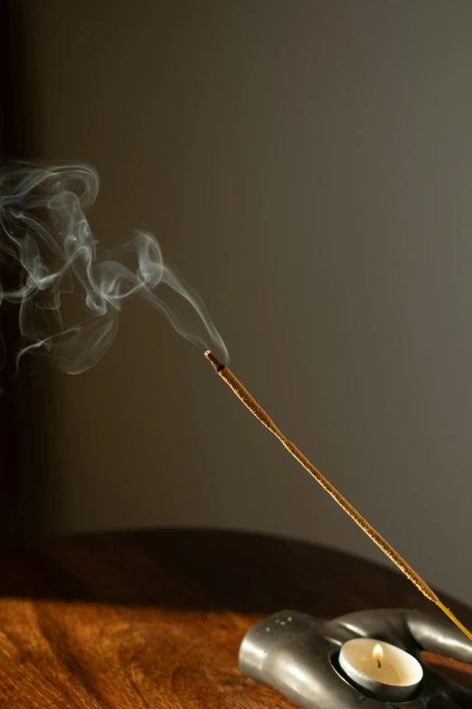 a close up of a incense stick on a table, inspired by Inshō Dōmoto, pexels, conceptual art, concept art. smoke, profile image, wooden staff, ilustration