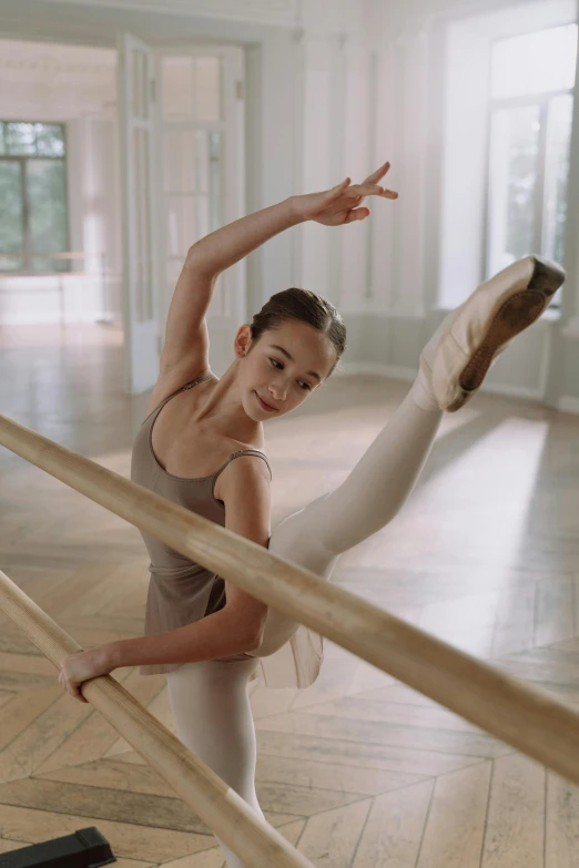 a young ballerina is practicing her ballet moves, pexels contest winner, arabesque, balance beams, david hamilton, brown, promotional image