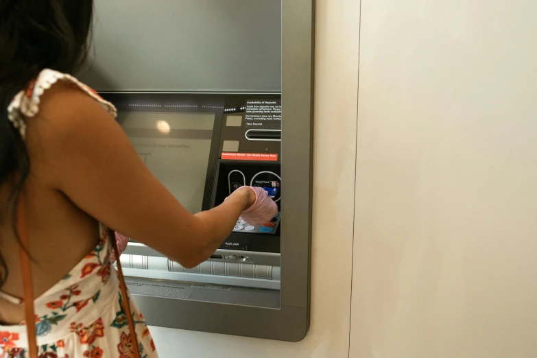 a woman standing in front of an atm machine, by Gina Pellón, pexels, hyperrealism, square, hands on counter, birdseye view, summertime