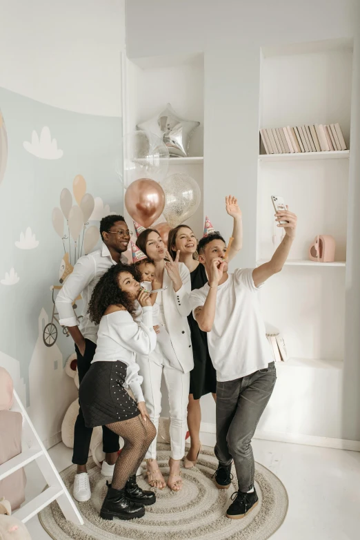 a group of people posing for a picture in a room, pexels contest winner, happening, white color scheme, taking a selfie, balloon, cell phone photo