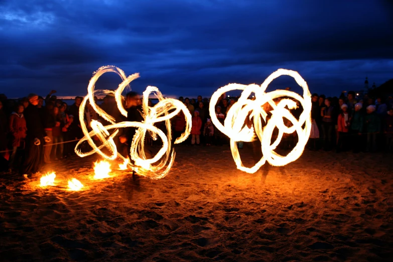 a group of people standing on top of a sandy beach, unsplash, kinetic art, fire poi, ilustration, intricate lights, profile image