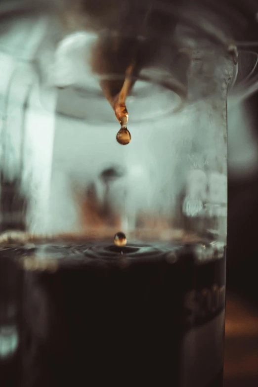 a pitcher filled with liquid sitting on top of a table, a macro photograph, by Andrew Domachowski, pexels contest winner, hanging upside down, intravenous drip, coffee machine, tear drop