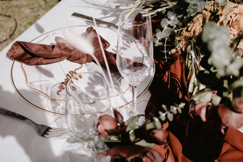 a close up of a plate on a table, by Caroline Mytinger, trending on unsplash, romanticism, maroon accents, al fresco, glassware, etched inscriptions