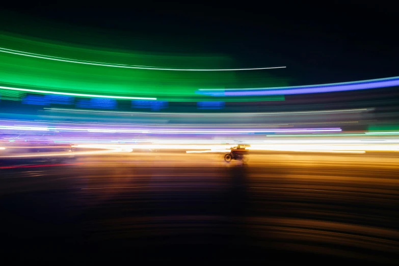 a blurry photo of a street at night, by Jan Rustem, unsplash contest winner, light and space, speeding on motorcycle, multicoloured, outline glow, blue and green light