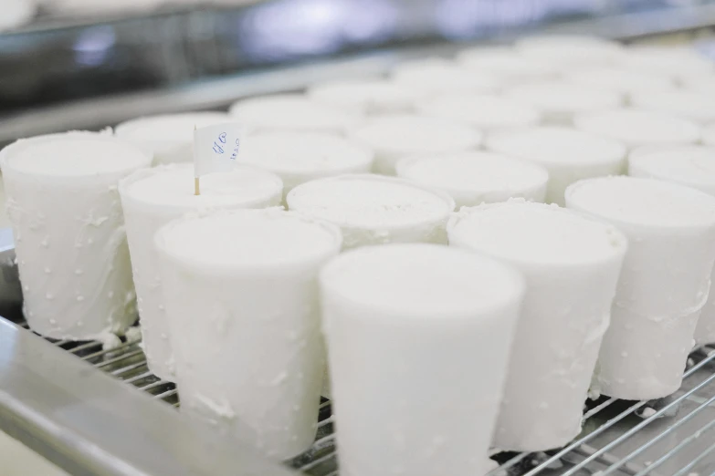 a close up of a tray of food on a conveyor belt, by Jessie Algie, unsplash, process art, yogurt, white candles, made of cheese, white sleeves