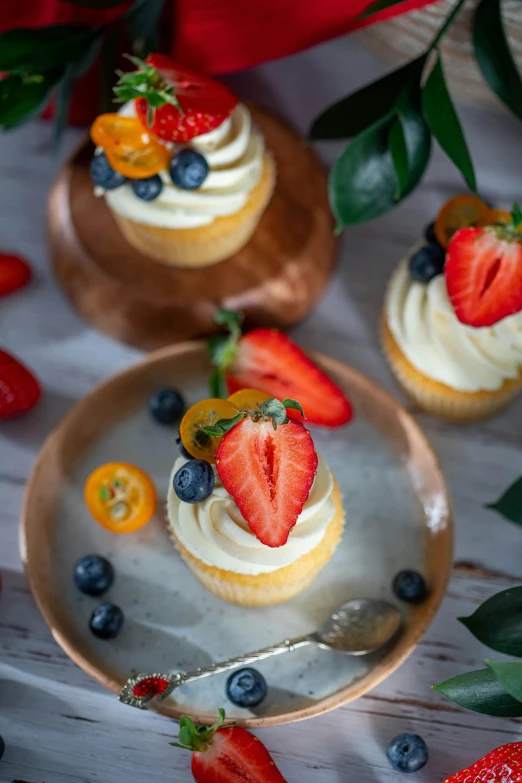 a plate of cupcakes topped with strawberries and blueberries, a still life, trending on pexels, gold, kek, vanilla, rustic