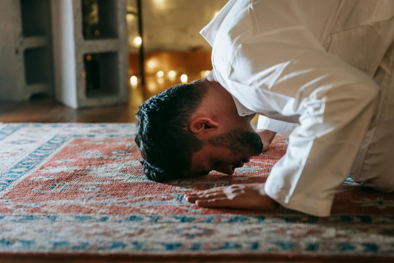 a man is doing a handstand on a rug, hurufiyya, kneeling in prayer, comforting, indoor setting, profile image