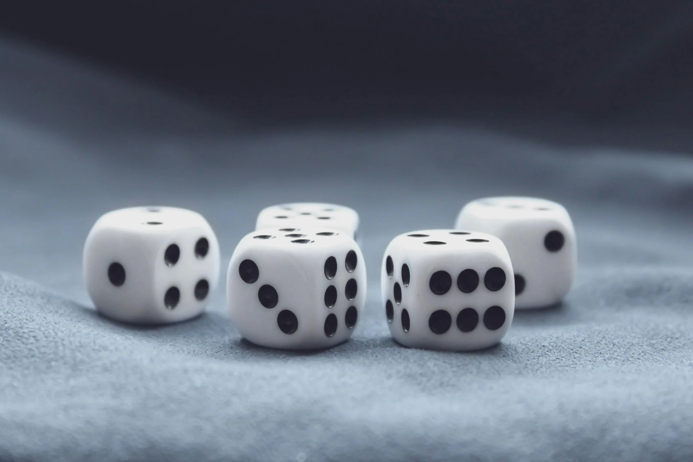 four white dice sitting on top of a blue cloth, a black and white photo, unsplash, six sided, miniatures, online casino logo, white limbo