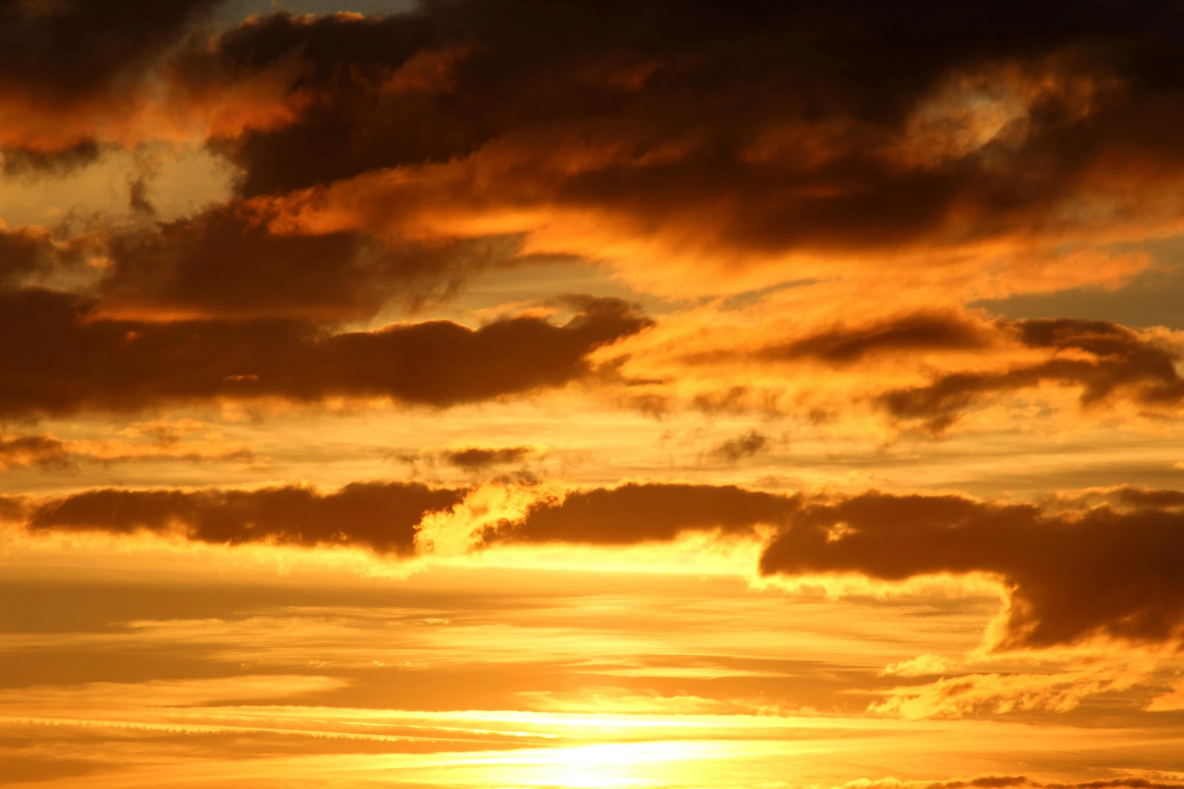 a large body of water under a cloudy sky, an album cover, by Ian Fairweather, pexels, orange sun set, yellow, a close-up, layered stratocumulus clouds