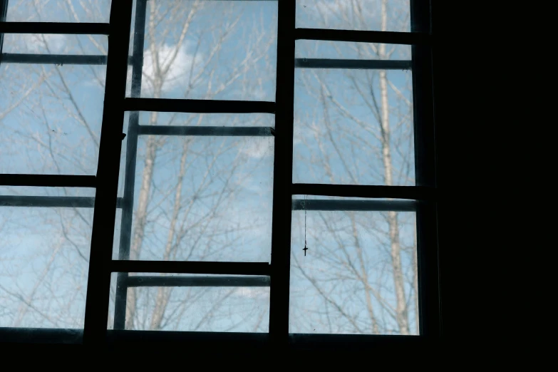 a close up of a window with a sky in the background, inspired by Elsa Bleda, shadows from trees, light blue sky, black windows, glass panes