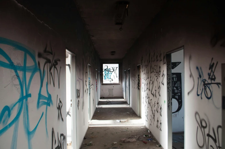 a long hallway with graffiti on the walls, graffiti, burned, mysterious exterior, instagram photo, poor buildings