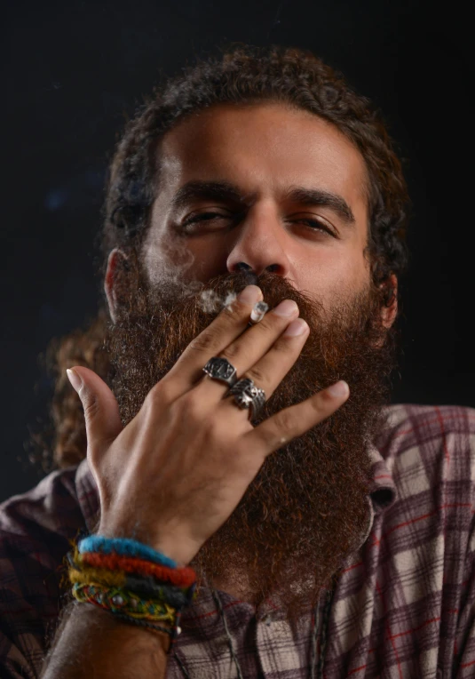 a man with a long beard smoking a cigarette, an album cover, by artist, trending on unsplash, hunter biden smoking crack, provocative indian, 15081959 21121991 01012000 4k, lgbtq