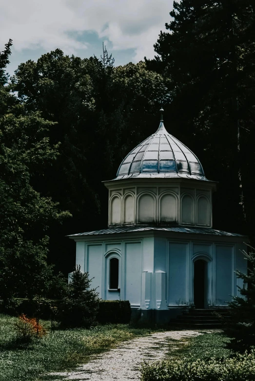 a small white building sitting in the middle of a forest, an album cover, unsplash contest winner, baroque, dome, botanic garden, orthodox, exterior photo