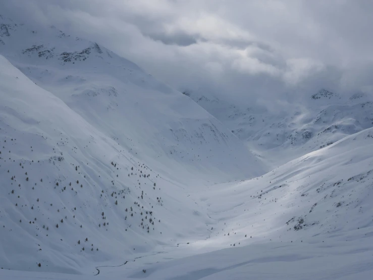 a man riding skis down a snow covered slope, by Werner Andermatt, pexels contest winner, hurufiyya, grey cloudy skies, view from high, the middle of a valley, slightly pixelated