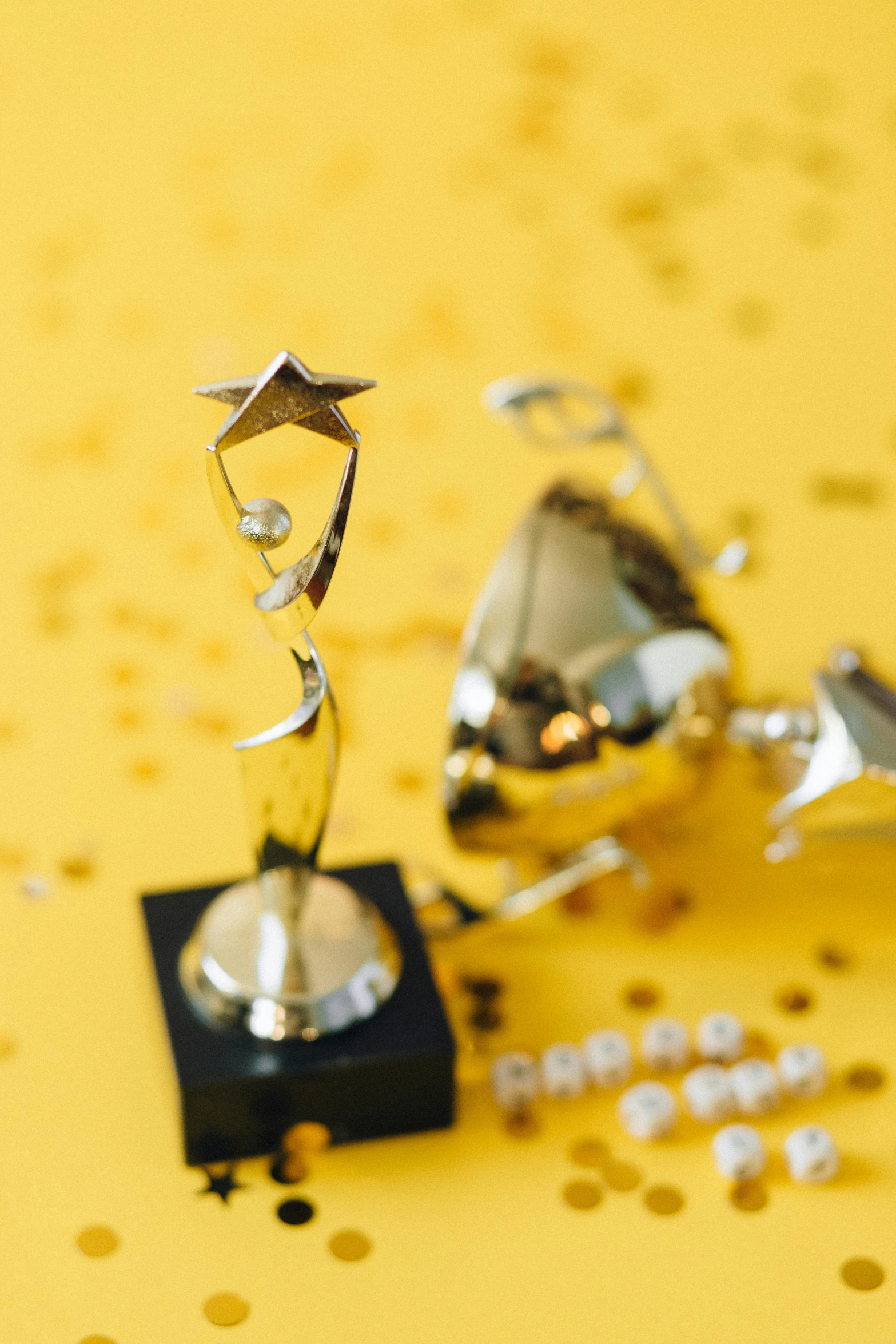 a couple of trophies sitting on top of a table, pexels contest winner, tiny stars, yellow carpeted, high angle close up shot, silver