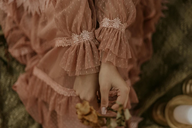 a close up of a person holding a flower, inspired by Elsa Bleda, rococo, pink dress, cottagecore hippie, victorian photo, brown clothes