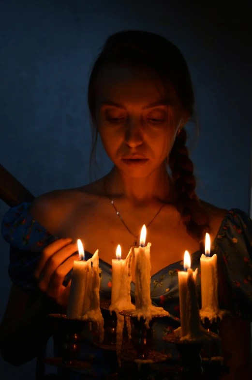 a woman holding a bunch of lit candles, inspired by Elsa Bleda, renaissance, looking sad, casting spells, profile image, trending photo