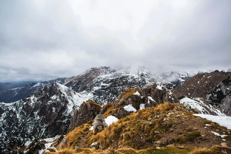 a man standing on top of a snow covered mountain, by Sebastian Spreng, unsplash contest winner, autumn mountains, overcast skies, panoramic, slovakia