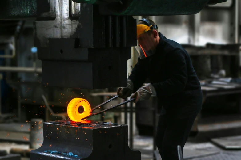 a man working on a metal object in a factory, by Arthur Sarkissian, pexels contest winner, person made out of glass, big hammer, avatar image, plating